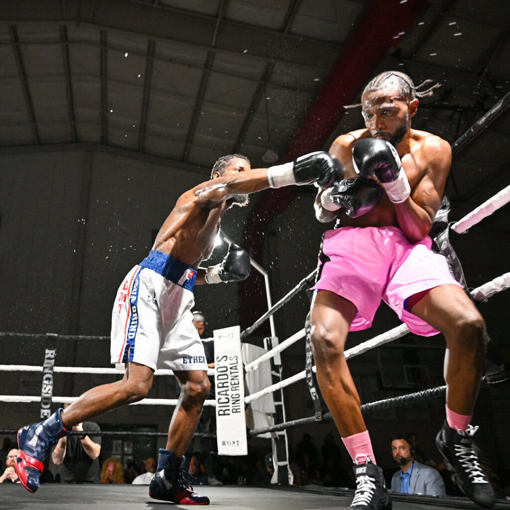 Boxer throws a punch at another boxer in the ring.