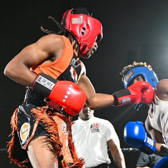 Boxer throws a quick left handed jab to the face of another boxer in blue.